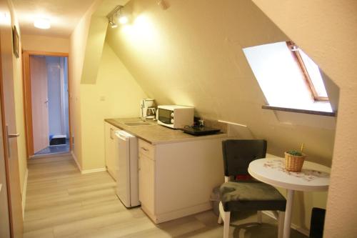 eine kleine Küche mit einem Waschbecken und einem Tisch in der Unterkunft Das Sofa Restaurant-Hotel-Spätkauf in Greifswald