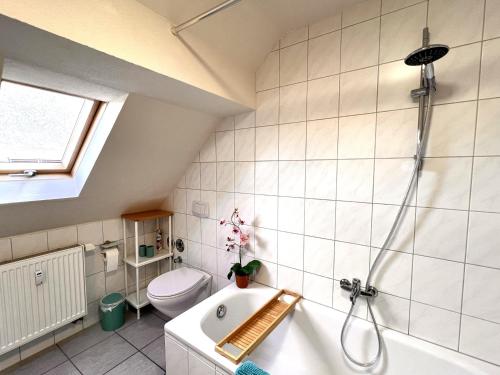 a bathroom with a bath tub and a toilet at Ferienwohnung Aurora - WLAN, 2 Schlafzimmer, TV, Küche, Bad, Waschmaschine in Malterdingen