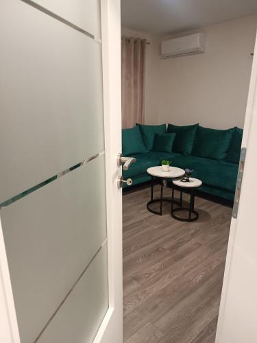 a living room with a green couch and a table at Apartment GORA in Međugorje