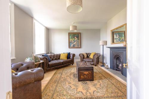 a living room with couches and a fireplace at Jaw-dropping view over the English Channel in Wroxall