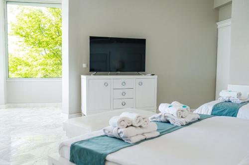 Zimmer mit 2 Betten, Handtüchern und einem TV in der Unterkunft Villa Bella Ohrid in Ohrid