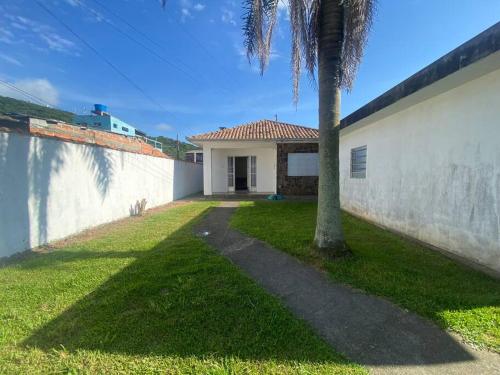 dom z palmą obok ściany w obiekcie Casa de Veraneio w mieście Laguna