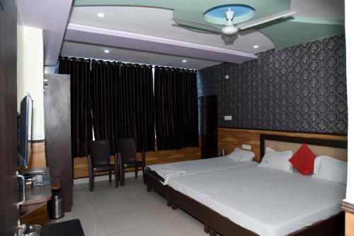 - une chambre avec un lit, une table et des chaises dans l'établissement TRPOTEL SUBMANGAL, à Gwalior