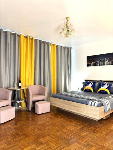 une chambre avec un lit et deux chaises dans l'établissement Chambre Arena Porte La Chapelle, à Paris