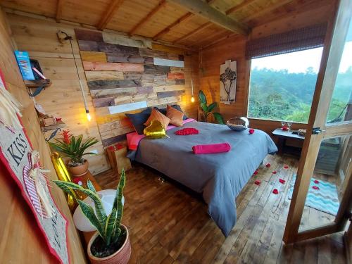 1 dormitorio con 1 cama en una cabaña de madera en Refugio Naturaleza en Armonia en San Francisco