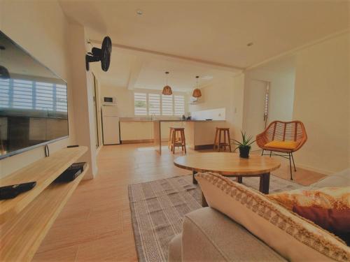 a living room with a couch and a table at Kozycoco - Suite Kozy - séjour tropical au calme in Schœlcher