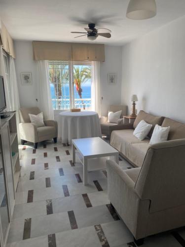a living room with a couch and chairs and a table at Apartamento en Primera Linea in La Herradura