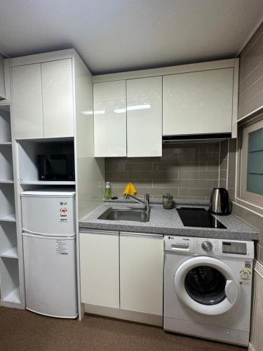 a kitchen with a sink and a washing machine at DASOM in Busan