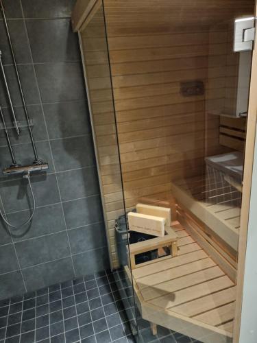 a bathroom with a shower and a wooden tub at Laskijantie10C in Ylläs