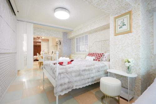 a bedroom with a white bed and a table at Papillon Paradis Higashi-Shinjuku in Tokyo