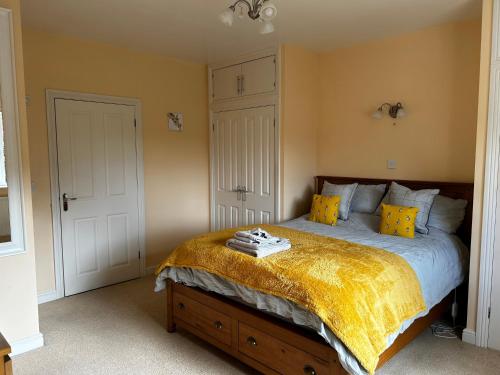 a bedroom with a bed with a yellow blanket on it at The Annexe in Street