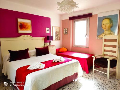 a bedroom with two beds and a window and a chair at B&B Domus de Janas Santa Teresa Gallura in Santa Teresa Gallura