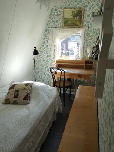ein Schlafzimmer mit einem Bett, einem Schreibtisch und einem Klavier in der Unterkunft Som hemma in Grästorp