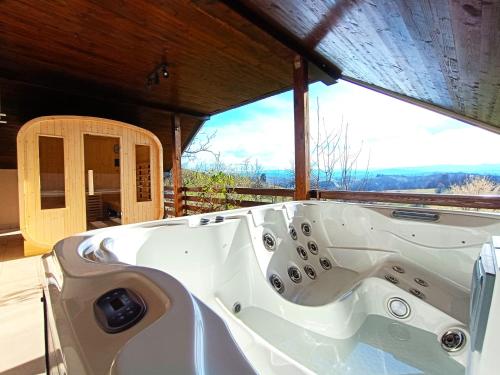 a white bath tub sitting in front of a window at Holiday Home Dandelion with Hot Tub & Sauna in Cetingrad