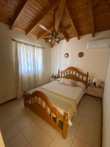 1 dormitorio con cama de madera y techo en Mendoza San Martin Sur Apart en Godoy Cruz