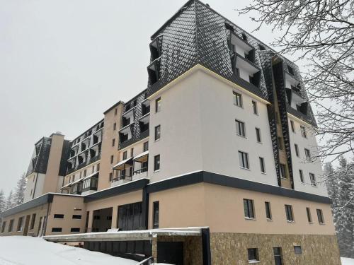 亞霍里納的住宿－ZLATNI JAVOR 312，雪中屋顶尖的建筑物