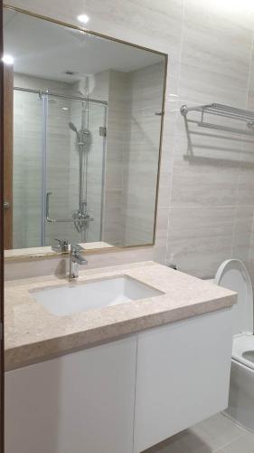 ein weißes Badezimmer mit einem Waschbecken und einem Spiegel in der Unterkunft Home Sweet Home in Haiphong