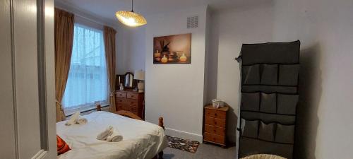 a bedroom with a bed and a dresser and a window at Pebbles Place in Brighton & Hove