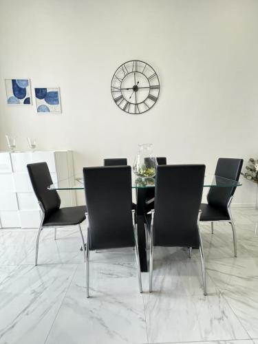 a dining room with a glass table and chairs and a clock at Tommy's Apartment in Pompei