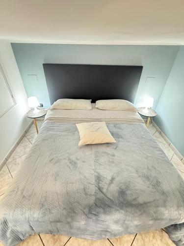 a large bed in a room with two tables at Tommy's Apartment in Pompei