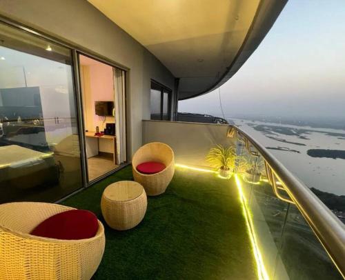 Habitación con 2 sillas y balcón con vistas. en Luxury Heights with City View and River View, en Noida
