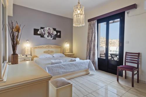 um quarto com uma cama, uma mesa e uma cadeira em Arkasa Bay Hotel em Arkasa