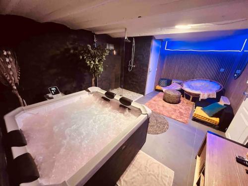 bañera grande en una habitación con luces azules en Maison avec spa proche paris en Saint-Denis