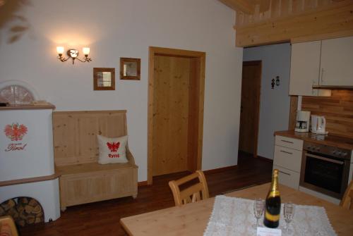 a kitchen with a table with a bottle of wine at Tirol Appartement Haus Zillertal in Zell am Ziller
