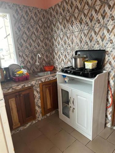 a kitchen with a stove with a pot on it at Appartement meublé Logbessou in Douala