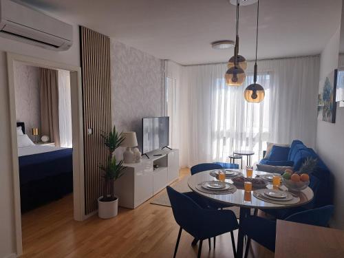 a living room with a table and blue chairs at Salona Lux in Klis