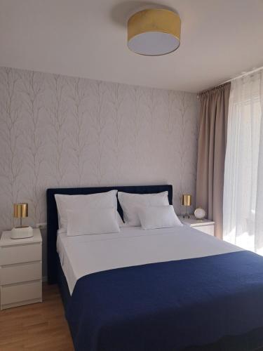 een slaapkamer met een blauw en wit bed en een raam bij Salona Lux in Klis