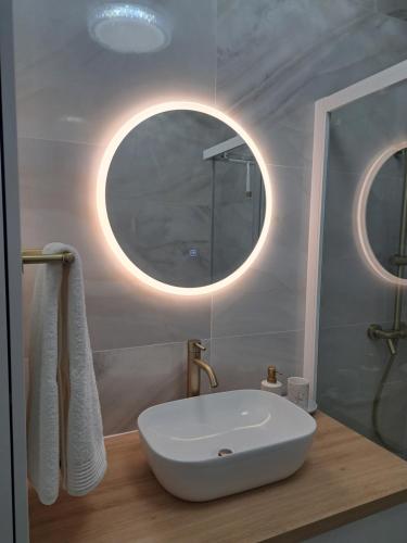 a bathroom with a sink and a round mirror at Salona Lux in Klis