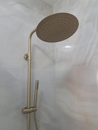 a shower with a shower head in a bathroom at Salona Lux in Klis