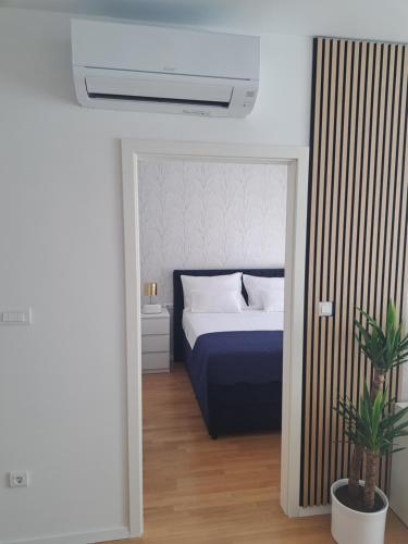 a bedroom with a blue bed and a plant at Salona Lux in Klis