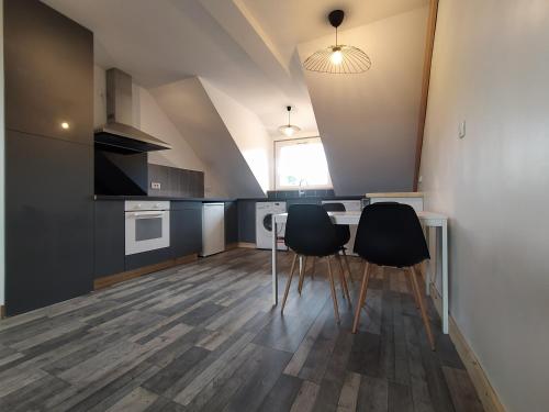 - une cuisine avec deux chaises et une table dans une chambre dans l'établissement Appartement vue sur mer, à Crozon