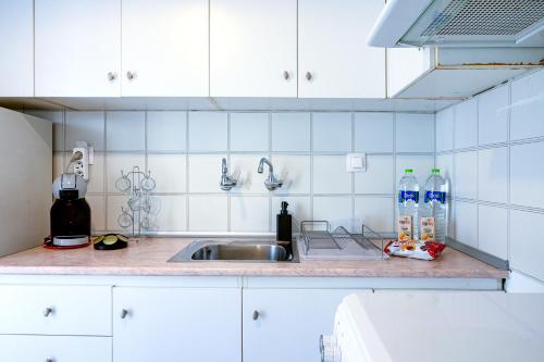 Una encimera de cocina con un fregadero y dos botellas de agua. en Thessaloniki Center Downtown Apartment, en Tesalónica