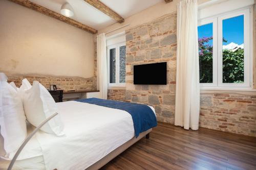 ein Schlafzimmer mit einem großen Bett und einer Steinmauer in der Unterkunft Azur Palace Luxury Rooms in Split
