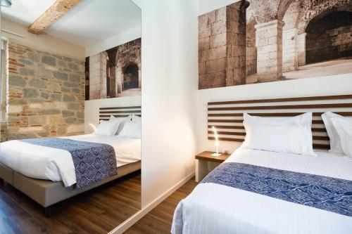 a bedroom with two beds and a brick wall at Azur Palace Luxury Rooms in Split