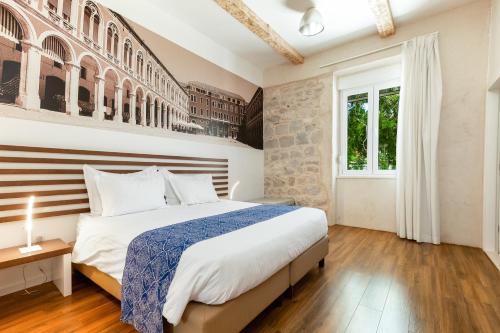 a bedroom with a large bed and a brick wall at Azur Palace Luxury Rooms in Split
