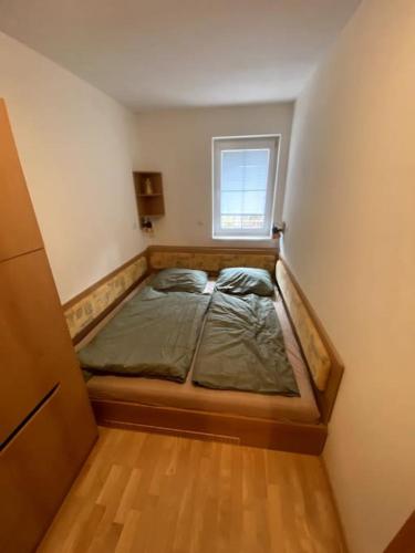 a bed in a small room with a window at Apartmán pod Prokopem in Železná Ruda