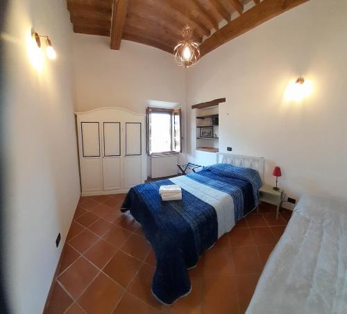 um quarto com uma cama azul num quarto em Vivi Palagio in Chianti em Aiola