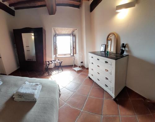 Schlafzimmer mit einem Bett, einer Kommode und einem Spiegel in der Unterkunft Vivi Palagio in Chianti in Aiola