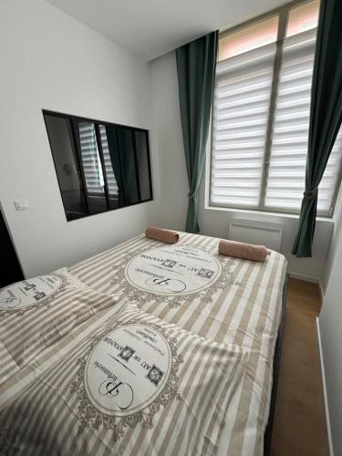 ein Schlafzimmer mit einem Bett mit einer karierten Decke in der Unterkunft La Villa Des Vents en bord de mer in Dunkerque