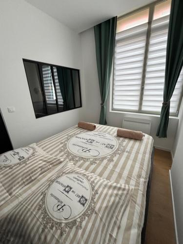 une chambre avec un lit avec une couverture à carreaux dans l'établissement La Villa Des Vents en bord de mer, à Dunkerque