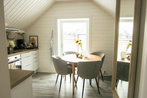 a dining room with a table and chairs in a kitchen at Koselig toppleilighet med fantastisk utsikt in Svolvær