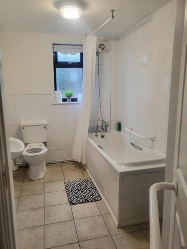 a bathroom with a tub and a toilet and a sink at The mill wheel in Hartshorne