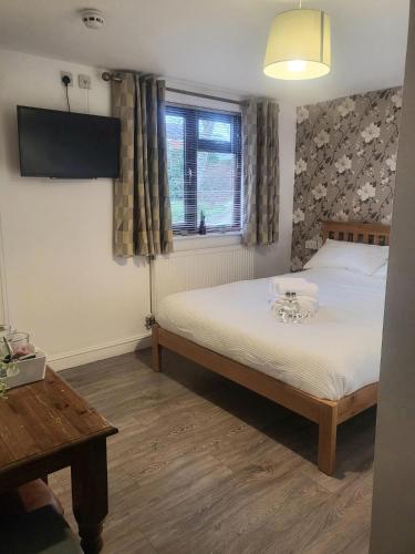 a bedroom with a bed and a tv and a window at The mill wheel in Hartshorne