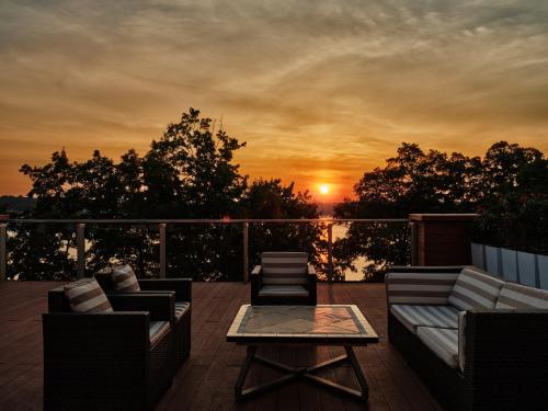 a deck with couches and a table and a sunset at GrandHotel Tiffi in Iława