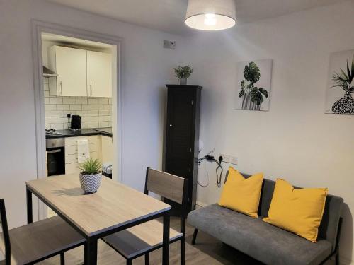 a kitchen and dining room with a table and yellow pillows at The mill wheel in Hartshorne