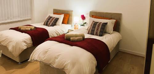 A spacious 3 bedroom house near UHCW, Free parking, Fast Wi-Fi, FHD TV, Netflix, Sleeps up to 9 في Wyken: سريرين في غرفة صغيرة بسريرين